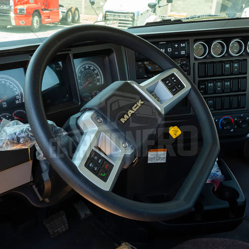 Interior de la cabina de un camión Mack, con un volante con controles integrados.