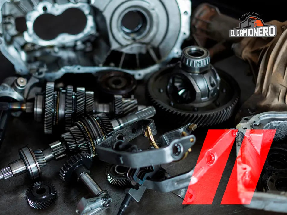 Refacciones para camiones pesados sobre mesa de trabajo, incluyendo engranes, ejes y piezas mecánicas. 